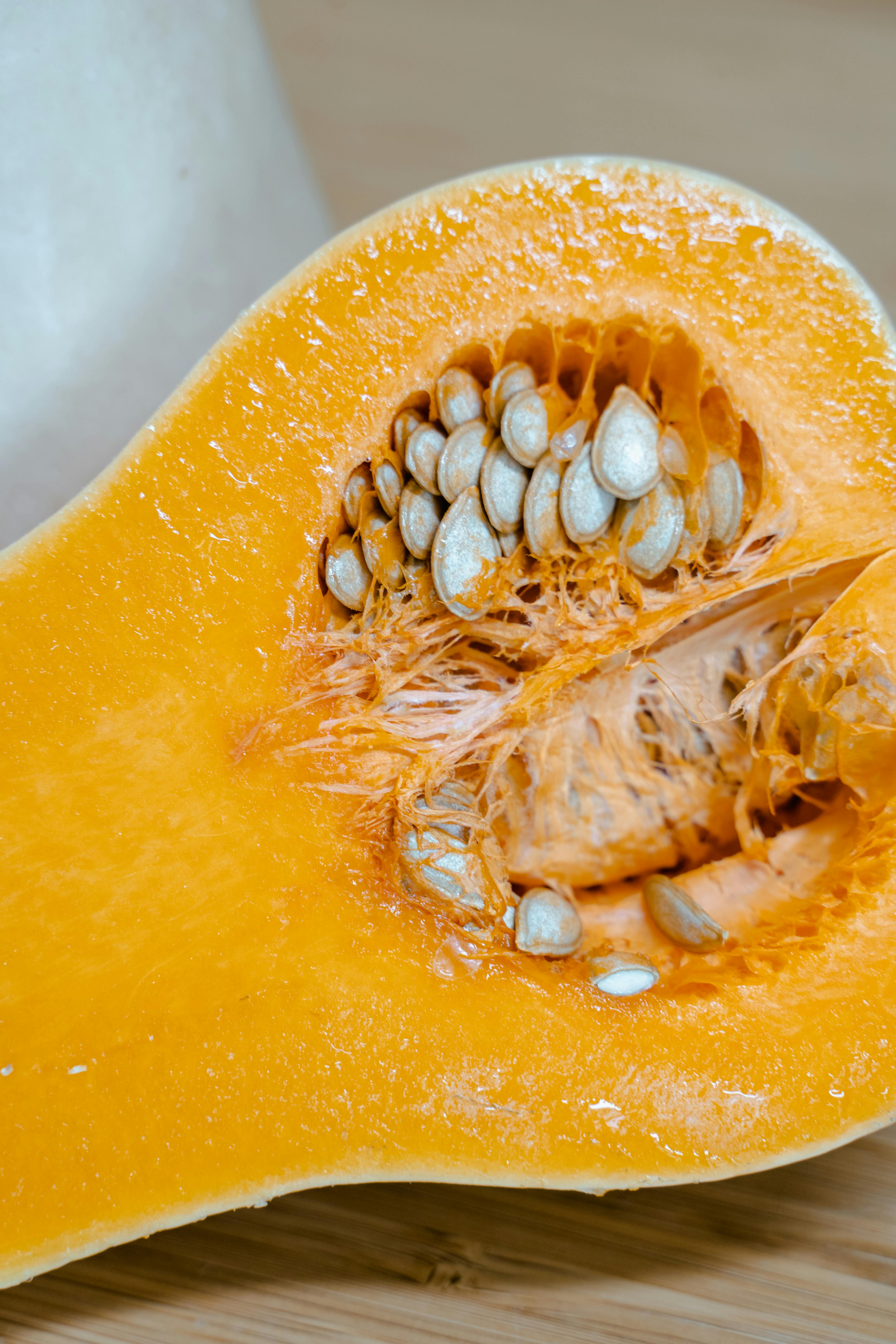 Close-up of a halved orange pumpkin on a wooden surface