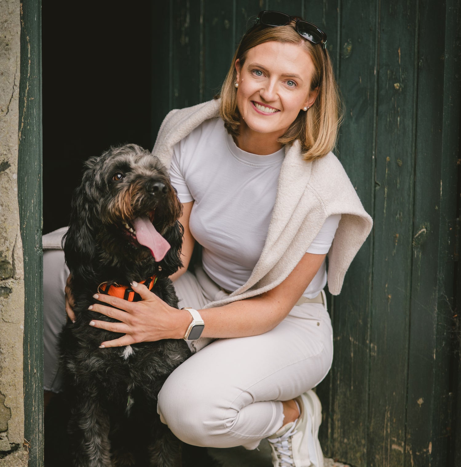 Darcy and Ted's founder, Joanne, with her dog Ted sitting against a dark wooden door