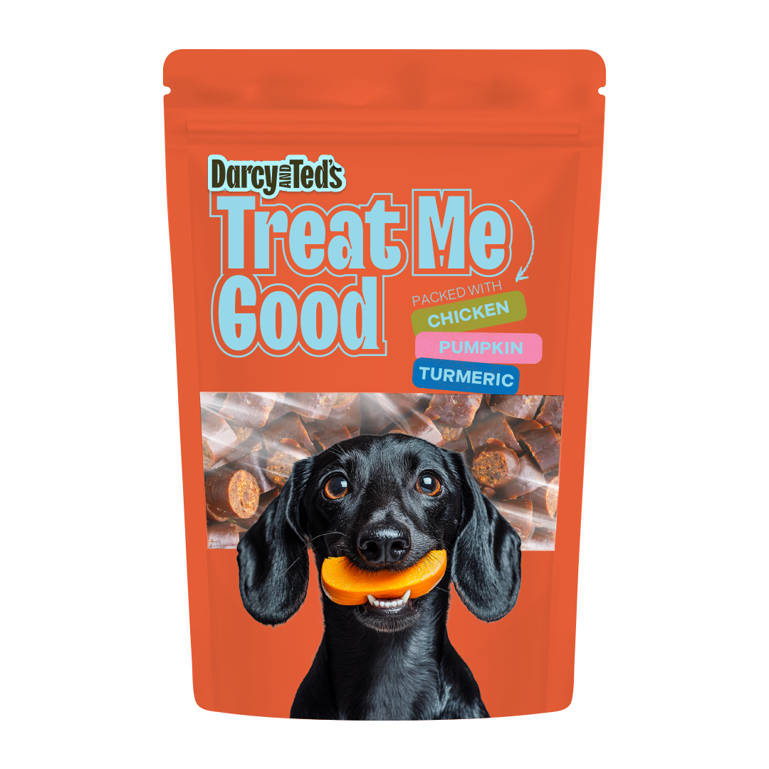 Orange package of Darcy and Ted's Chicken Treat Me Good dog treats with a black dog holding a piece of pumpkin.