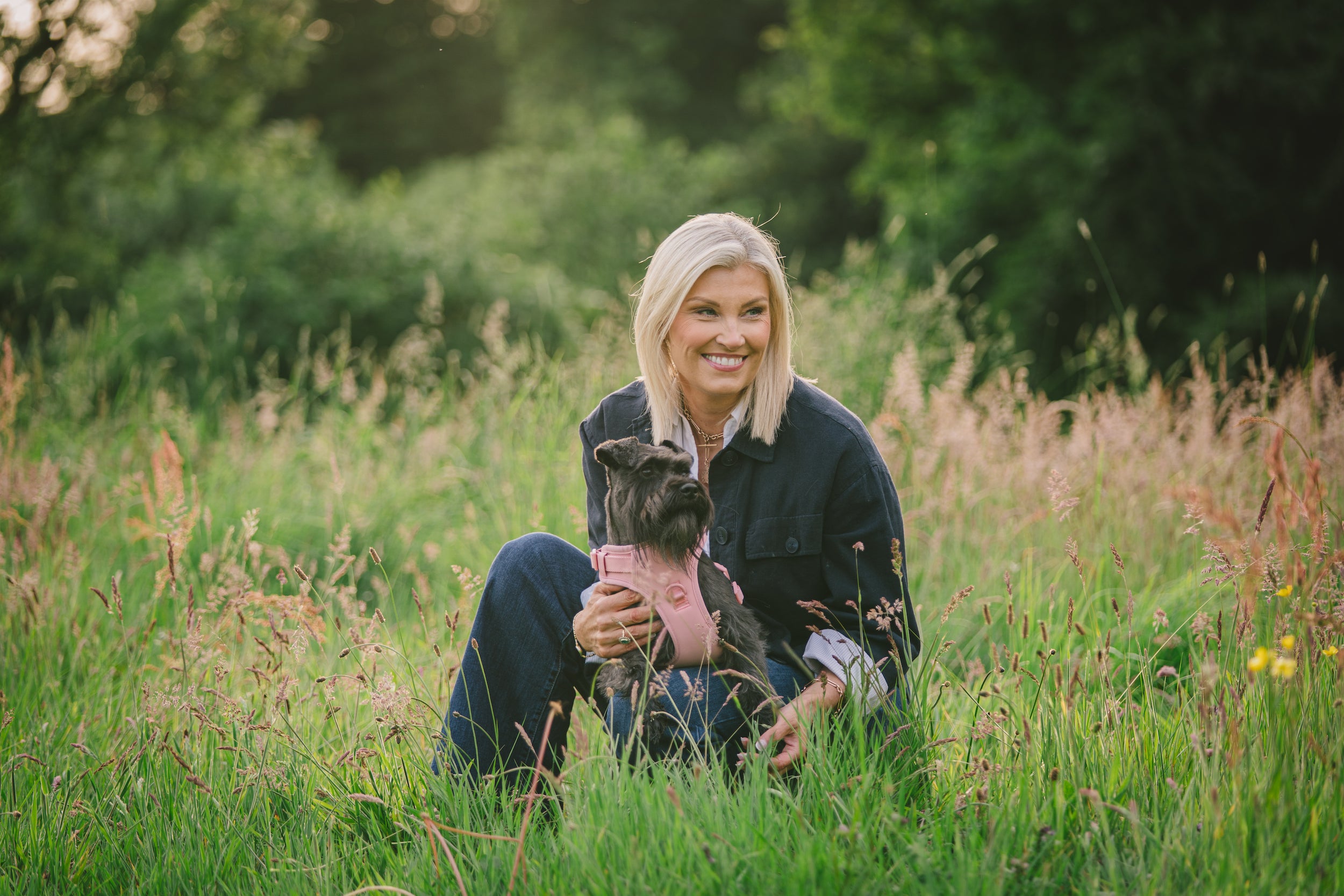 Darcy and Ted's founder, Gillian, sitting in a field with her dog, Darcy