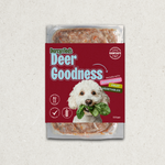 Darcy and ted raw dog food package labeled 'Deer Goodness' with a dog holding greens on a textured gray background