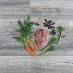 Raw lamb meat with vegetables on a wooden surface