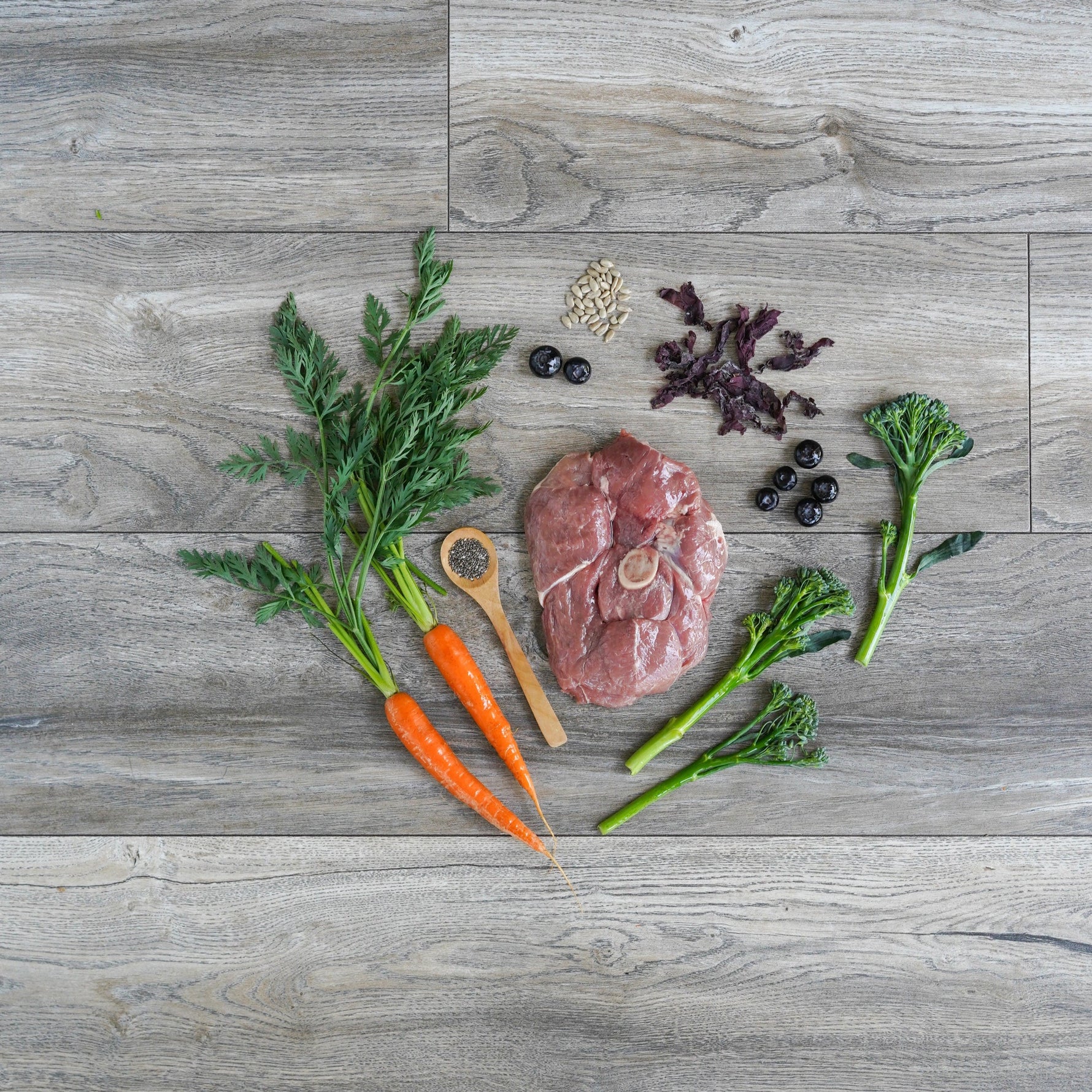 Raw lamb meat with vegetables on a wooden surface