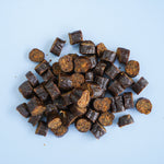 Pile of darcy and teds beef treats on a light blue background