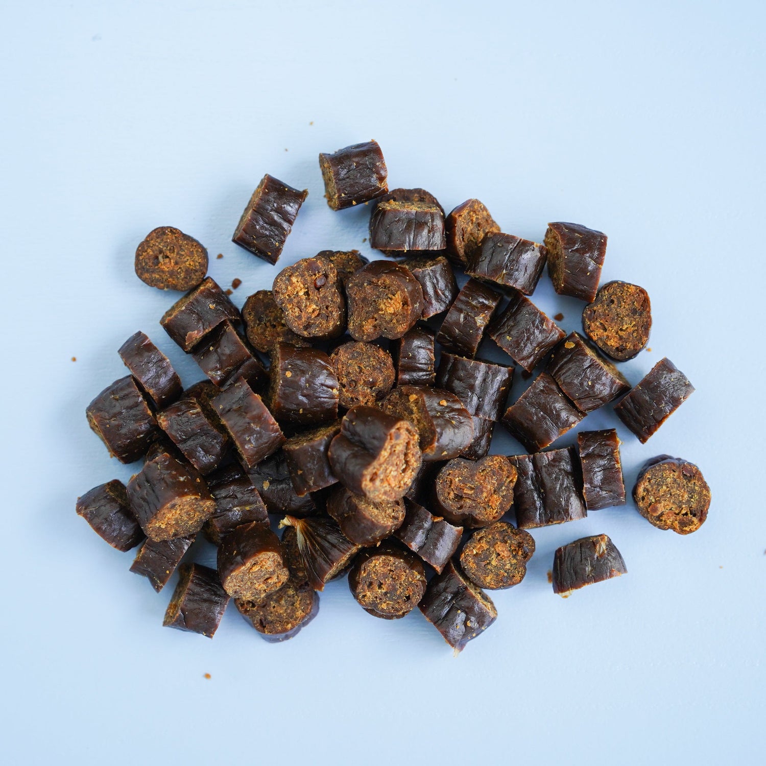 Pile of darcy and teds beef treats on a light blue background