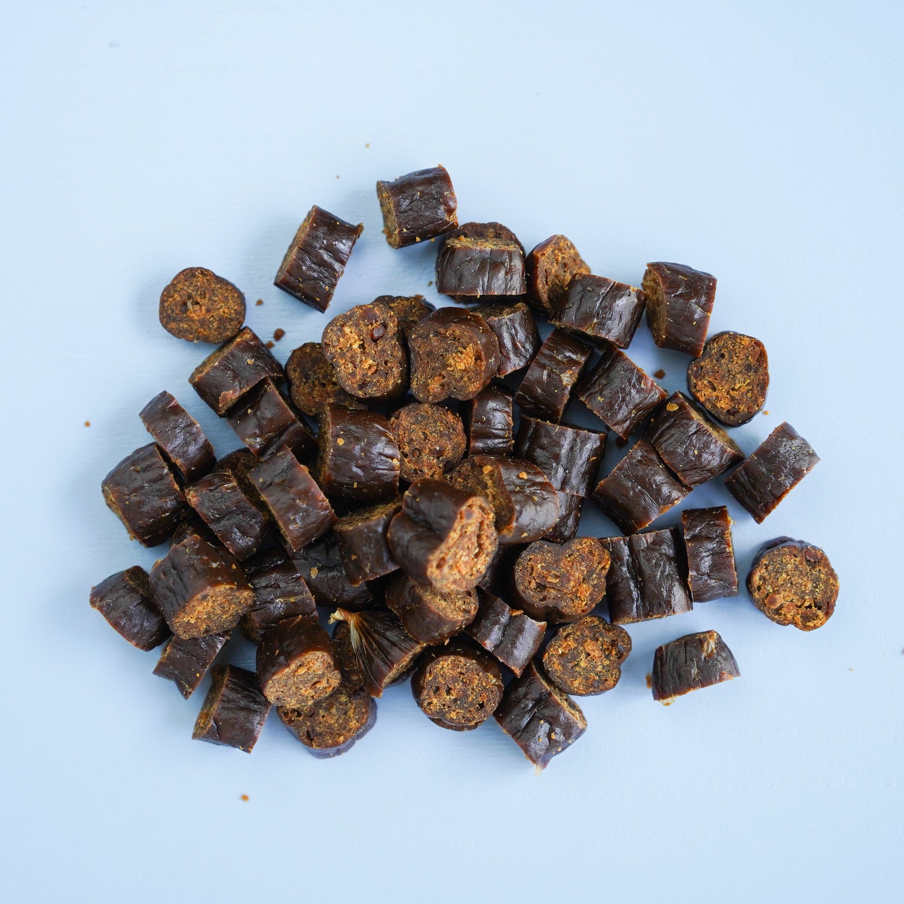 Pile of darcy and teds beef treats on a light blue background